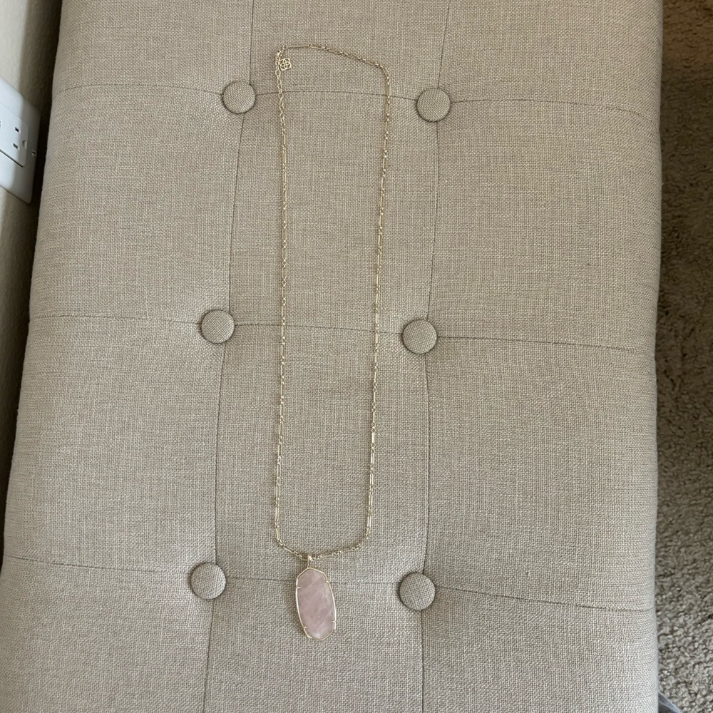Long gold Kendra Scott necklace with pink stone